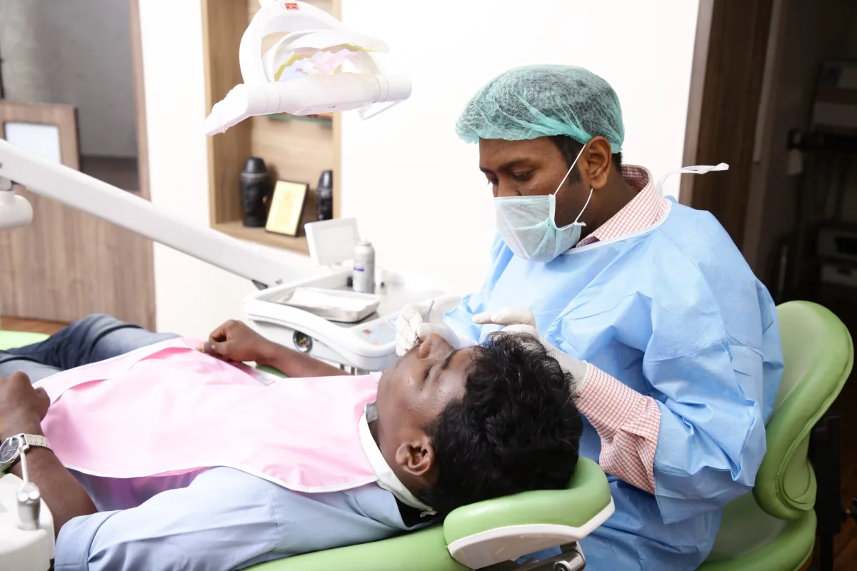 Dentist treating a patient in the chair at Arasu Dental Care, Coimbatore